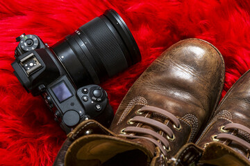 A mirrorless camera next to brown leather boots