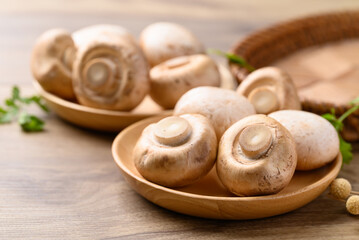 Fresh Champignon mushroom or button mushroom in bowl on wooden background