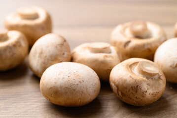 Fresh Champignon mushroom or button mushroom on wooden background