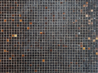 Texture of old brown, black and orange wall tiles