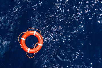 Orange lifebuoy floating on the surface of the ocean, needed help for those who fall overboard. 