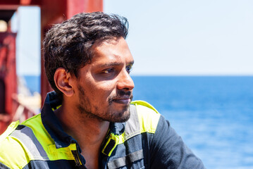 Lonely seafarer on board of the cargo ship, he is looking into the open sea thinking about his home...
