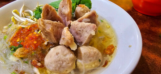 Bakso, indonesian meatball style served with beef broth soup and noodle springkled with fried onion and spring onion coupled with chili sauce on the top
