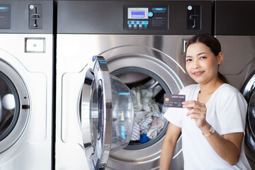 Woman using self-service washing machine.