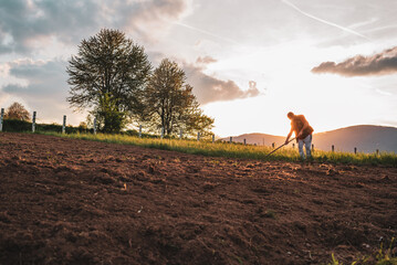 Farmer working on an agricultural fields in spring.