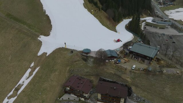 Saalbach-Hinterglemm (Austria) ski resort with melting snow, tilt-down shot, aerial view