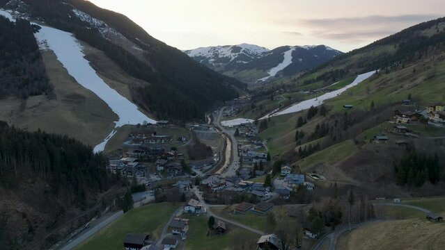 Alpine village of Saalbach-Hinterglemm (Austria) at dusk with snow-covered slopes