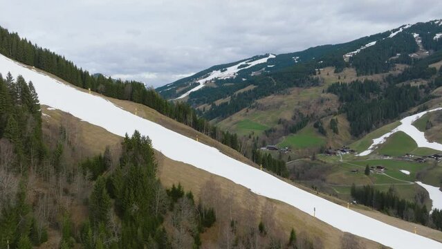 Melting snow on slopes of Saalbach-Hinterglemm (Austria), patchy green, aerial shot