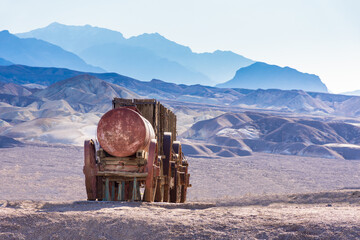 Antique mule wagon for transporting borax in Death Valley. Hot desert sun, silhouettes of mountains...