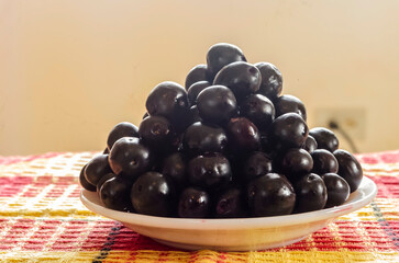 Closeup Side View of a Plate Of Jamun Fruits