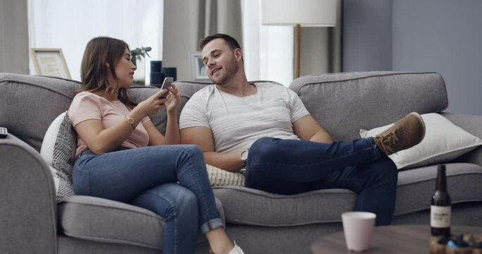 Infidelity, couple and caught cheating on phone with fight, conflict or argument about social media. App, divorce or breakup with man and woman on sofa in home living room for online communication