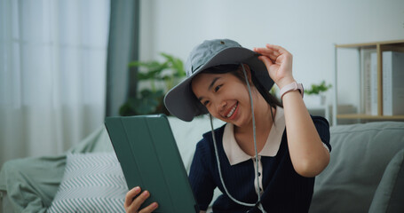 Selective focus of Asian teenager woman sitting on sofa video call with friend while packing suitcase luggage for travelling, backpacker travel concept. - 772700424