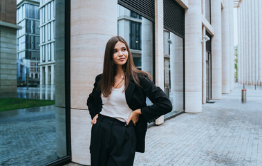 Confident young woman in professional attire outside modern architecture office building