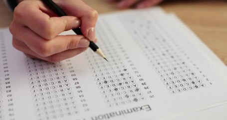 Student or trainee taking exam fills out test in pencil