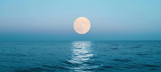 Full moon over blue sea water in pastel sky, nature background