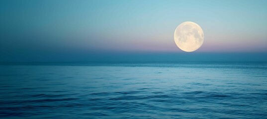 Full moon over blue sea water in pastel sky, evening natural background