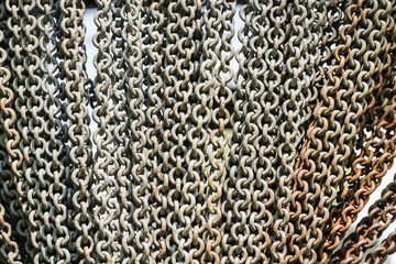 Big iron chain curtain on entrance grey red brown rusty abstract background