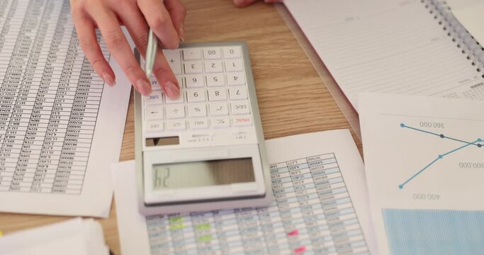 Analyzing financial data using a calculator at workplace