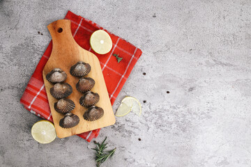 Top view of pigeon clams on wooden board over grey background