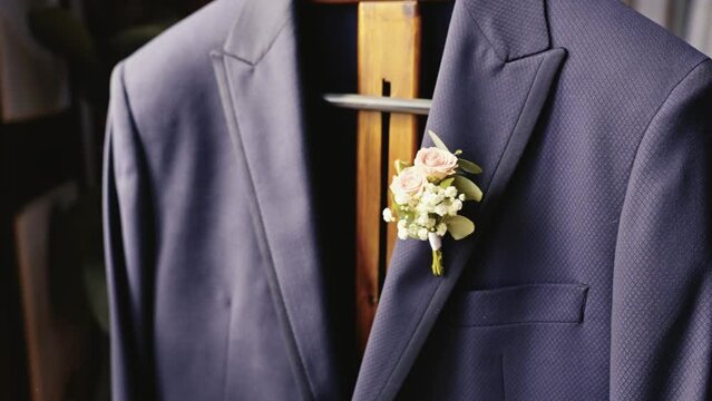decorative flower bouquet hanging from a wedding groom's blazer