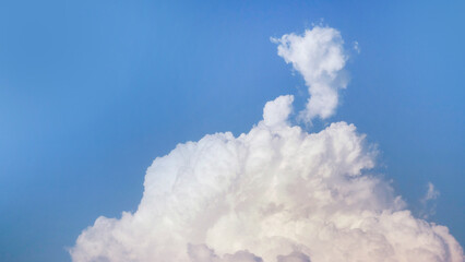 White fluffy clouds open for fantasy idea shape against bright blue sky for background with copy space, graphic resource, cloud motion from the wind
