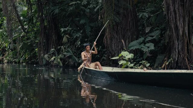 Young tribe man paddling in a Canoe in Amazon