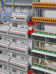 An electric switchboard with modules for protection and control of electrical loads, mounted on din rails.