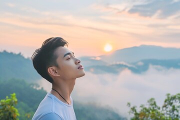Asian man enjoying the fresh morning air on the mountain, calming refreshing