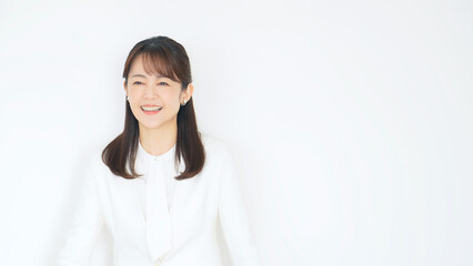 白いスーツを着た爽やかなミドル女性
