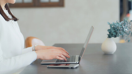 Naklejka premium A woman using a laptop and smartphone indoors