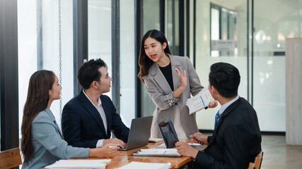 Businesswoman presenting graph chart to colleagues in a meeting. Professional corporate team discussion in modern office. Corporate business and teamwork concept.