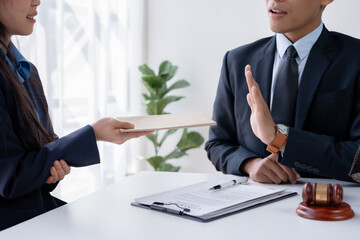Ethical lawyer at a desk rejecting a bribe, with important legal documents and a justice scale in...