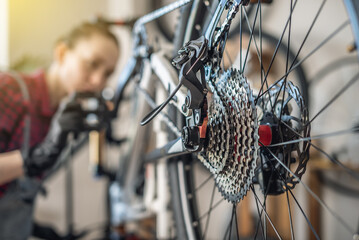 Woman is performing maintenance on mountain bike. Concept of fixing and preparing the bicycle for...