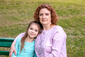Portrait of a happy woman and daughter smiling and looking at the camera.