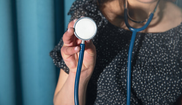 Caucasian woman holding a medical stethoscope.