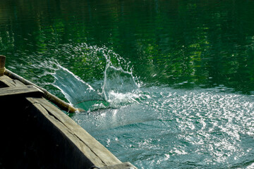 A wonderful splash created as the paddle hits the green water,  Puravimala