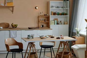 Background image of cozy kitchen interior with modern white counters and wooden table set for breakfast copy space