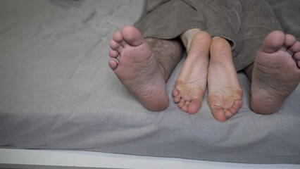 Couple in bed making love. male and female legs. Married couple in bed, making love at home, romance, the convergence of the legs of a woman and a man