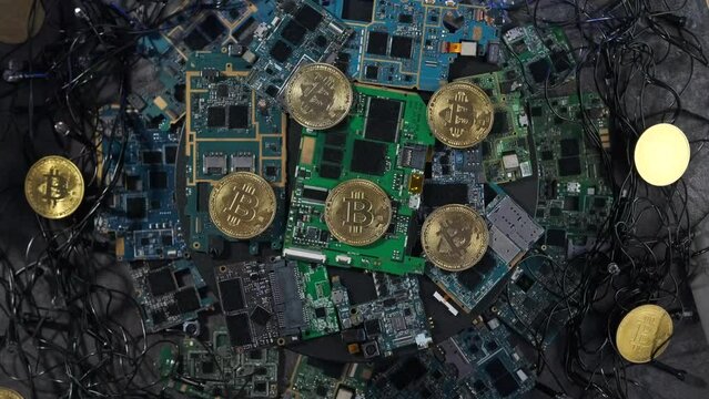 In pile motherboards of computer scattered coins cryptocurrency of bitcoin with glare blue red lights, futuristic innovation digital technology background, top view.
