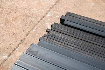 A stack of steel profiles in different shapes. They are used in construction and manufacturing.
