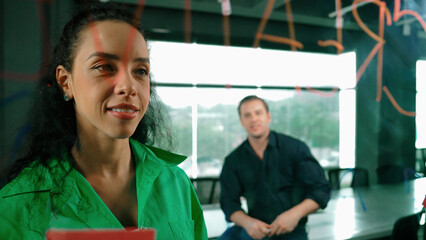 Smart businesswoman leader writing creative business idea while male caucasian investor listen...