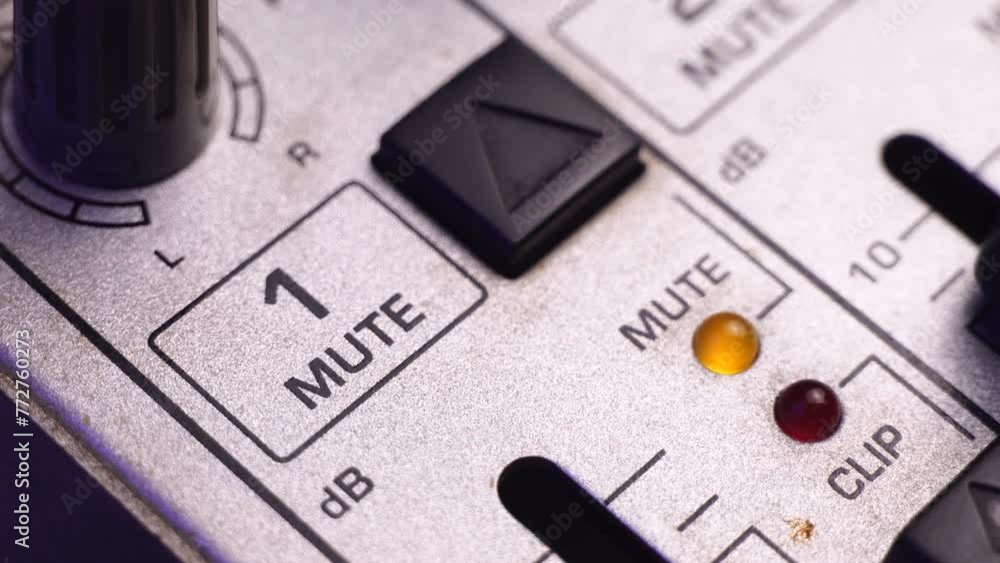 Poster muting channel 1 on mixing audio console, pressing mute button, macro close up