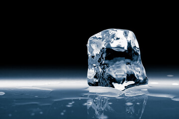 Crystal clear natural transparent shiny single ice cube, isolated on a black background.