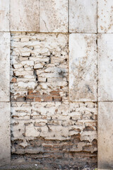Wall of a house with collapsed facing tiles