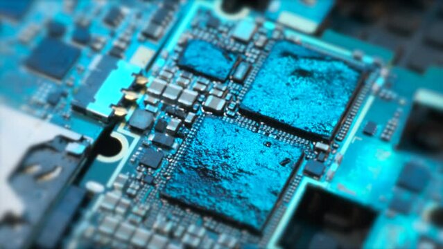 Microchips surface electronic device, top view tracking macro shot, components for computers motherboard and chip with in blue neon lights background. 