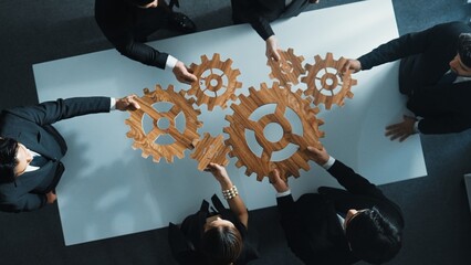 Top view of smart business people gather wooden cog together at meeting. Group of project manager...