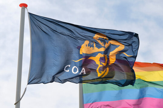Flag of the COA and a rainbow flag at the entrance of a temporary housing location for asylum seekers or AZC in the Netherlands
