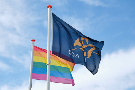 Flag of the COA and a rainbow flag at the entrance of a temporary housing location for asylum seekers or AZC in the Netherlands	