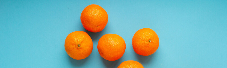 Fresh orange fruits banner with light blue background. Vibrant photo of citrus food top view. Vitamin C