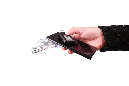 Hand holding banknotes and mobile phone and car keyless remote